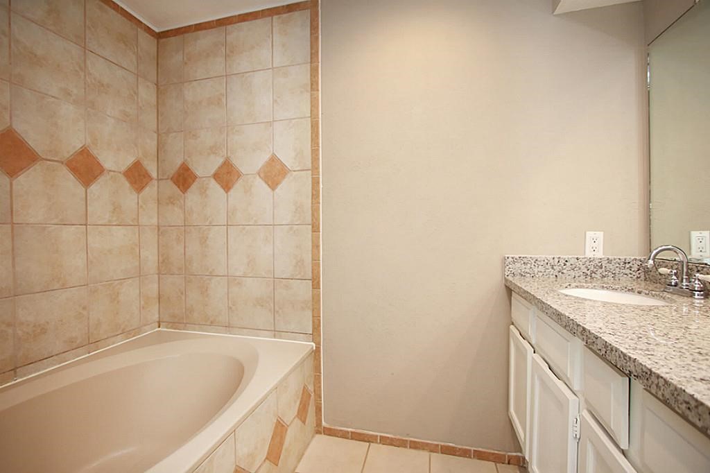 23315 Montague Drive Spring, TX 77373 - Photo 16 of 24 a bathroom with a granite countertop sink and a bathtub