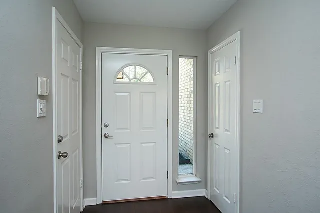 an empty room with wooden floor front door