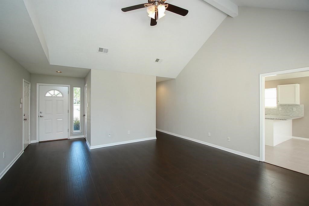 23315 Montague Drive Spring, TX 77373 - Photo 3 of 24 an empty room with wooden floor chandelier fan and windows