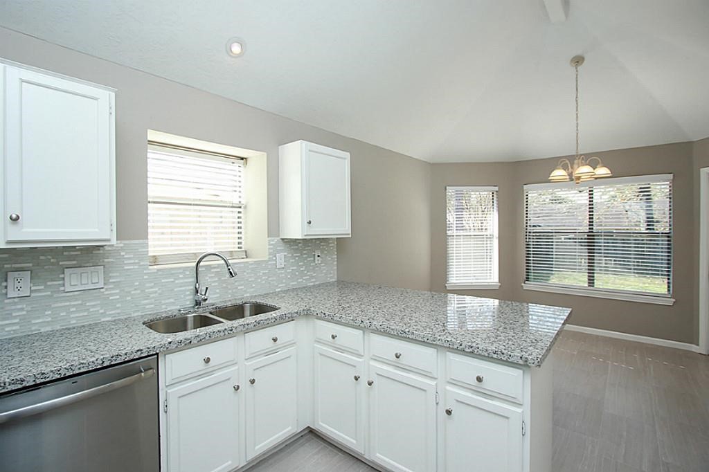 23315 Montague Drive Spring, TX 77373 - Photo 7 of 24 a kitchen with granite countertop a sink a stove and cabinets