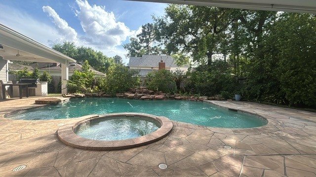 23 Rustic View Court The Woodlands, TX 77381 - Photo 14 of 18 Inviting pool spa surrounded by 2 covered raised pavilions home to outdoor kitchen custom built dining table + covered living area warmed by outdoor fireplace