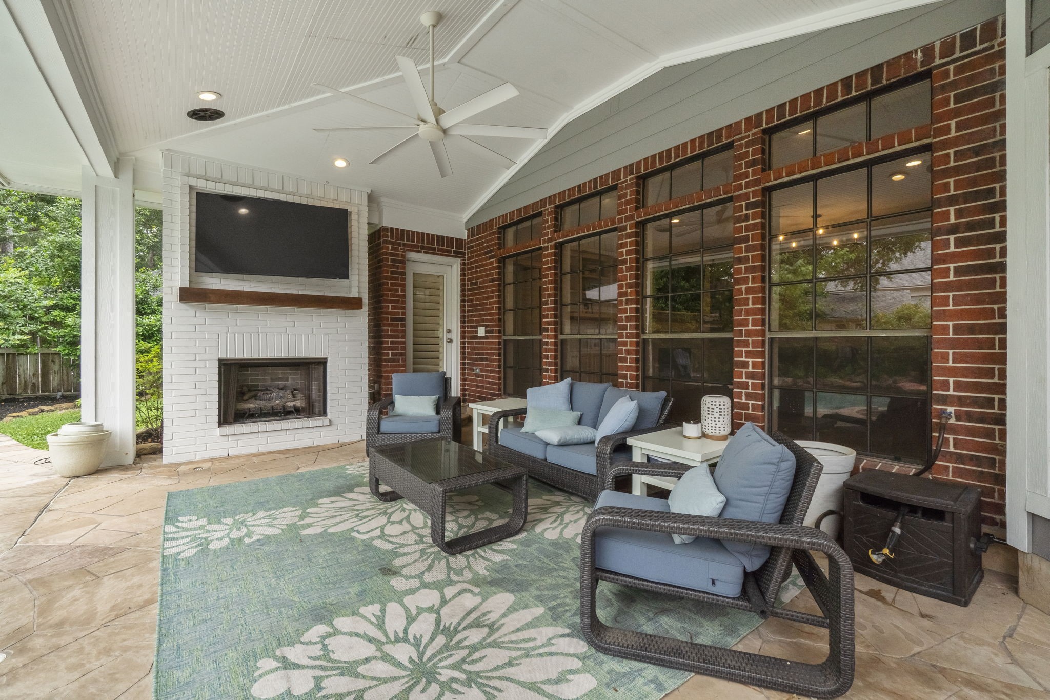 23 Rustic View Court The Woodlands, TX 77381 - Photo 18 of 18 Awe inspired covered outdoor living space complete with ambient gas log fireplace, ceilings fans, recessed lighting and wall mounted big screen TV