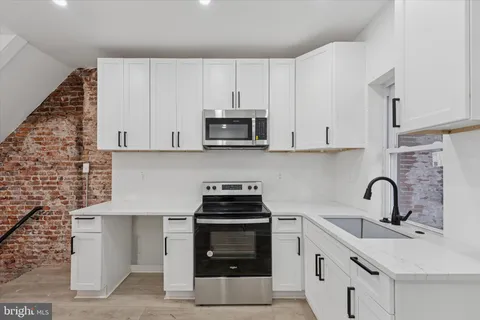 a kitchen with stainless steel appliances granite countertop a refrigerator sink and microwave