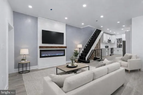 a view of an empty room with wooden floor and stairs