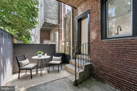 a view of a door of the house with a bench