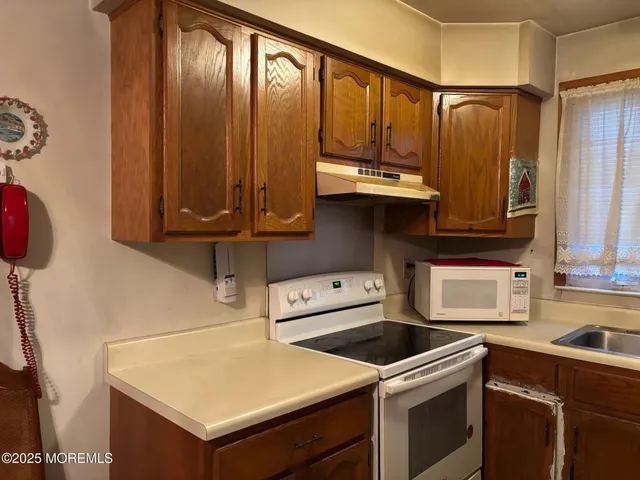 a kitchen with stainless steel appliances wooden cabinets and a stove top oven