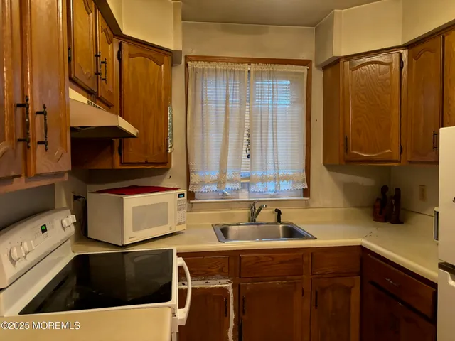 a kitchen with a sink a stove and cabinets