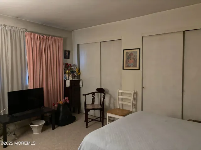 a bedroom with a bed and a television