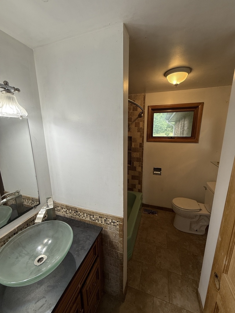 1826 Albert Lane Wilmington, IL 60481 - Photo 11 of 18 a bathroom with a granite countertop sink toilet and mirror