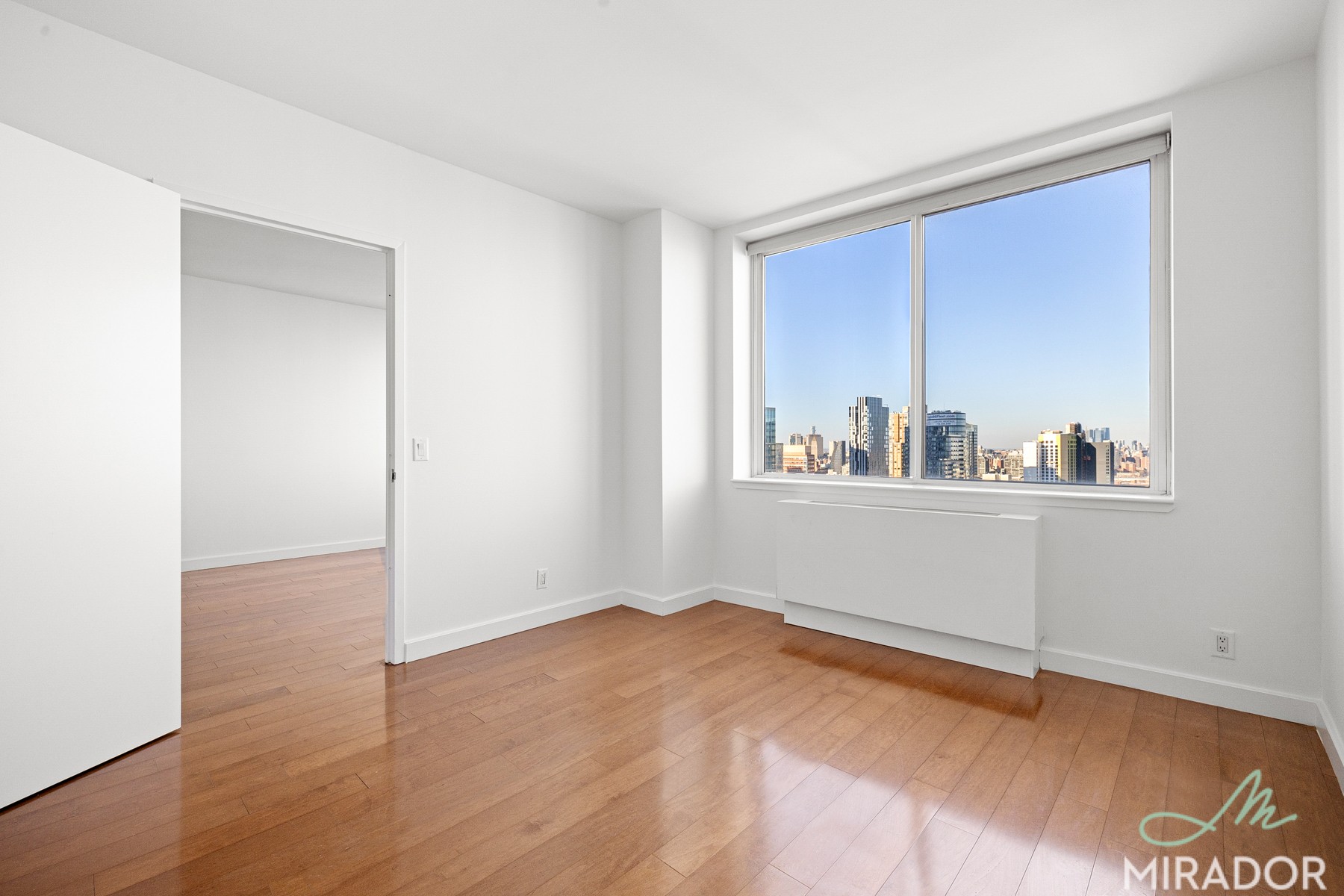 80 Dekalb Avenue, Unit 30C Brooklyn, NY 11201 - Photo 12 of 28 a room with a wooden floor and a window