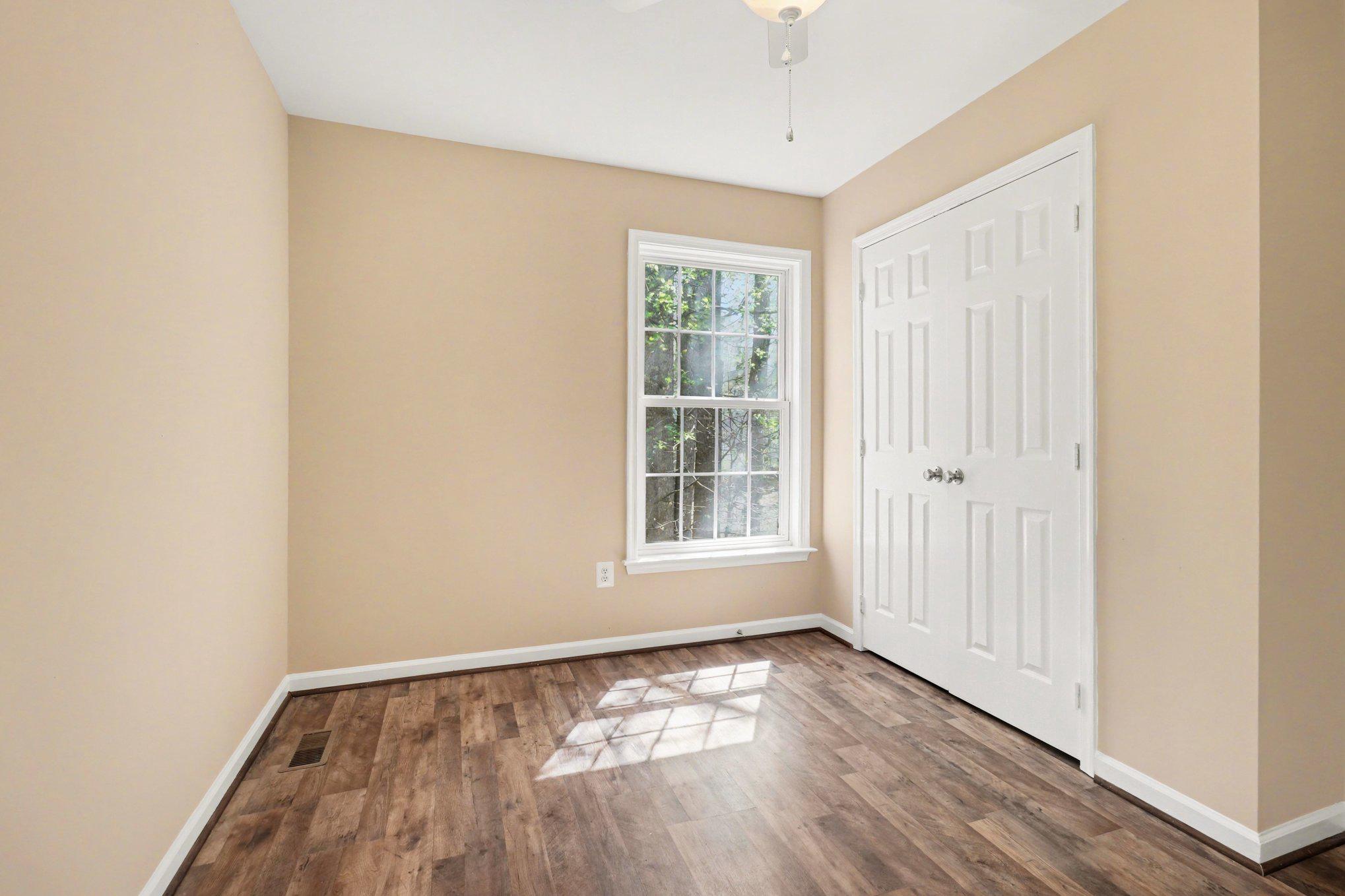876 Campers Lane Ruther Glen, VA 22546 - Photo 11 of 27 an empty room with wooden floor and windows