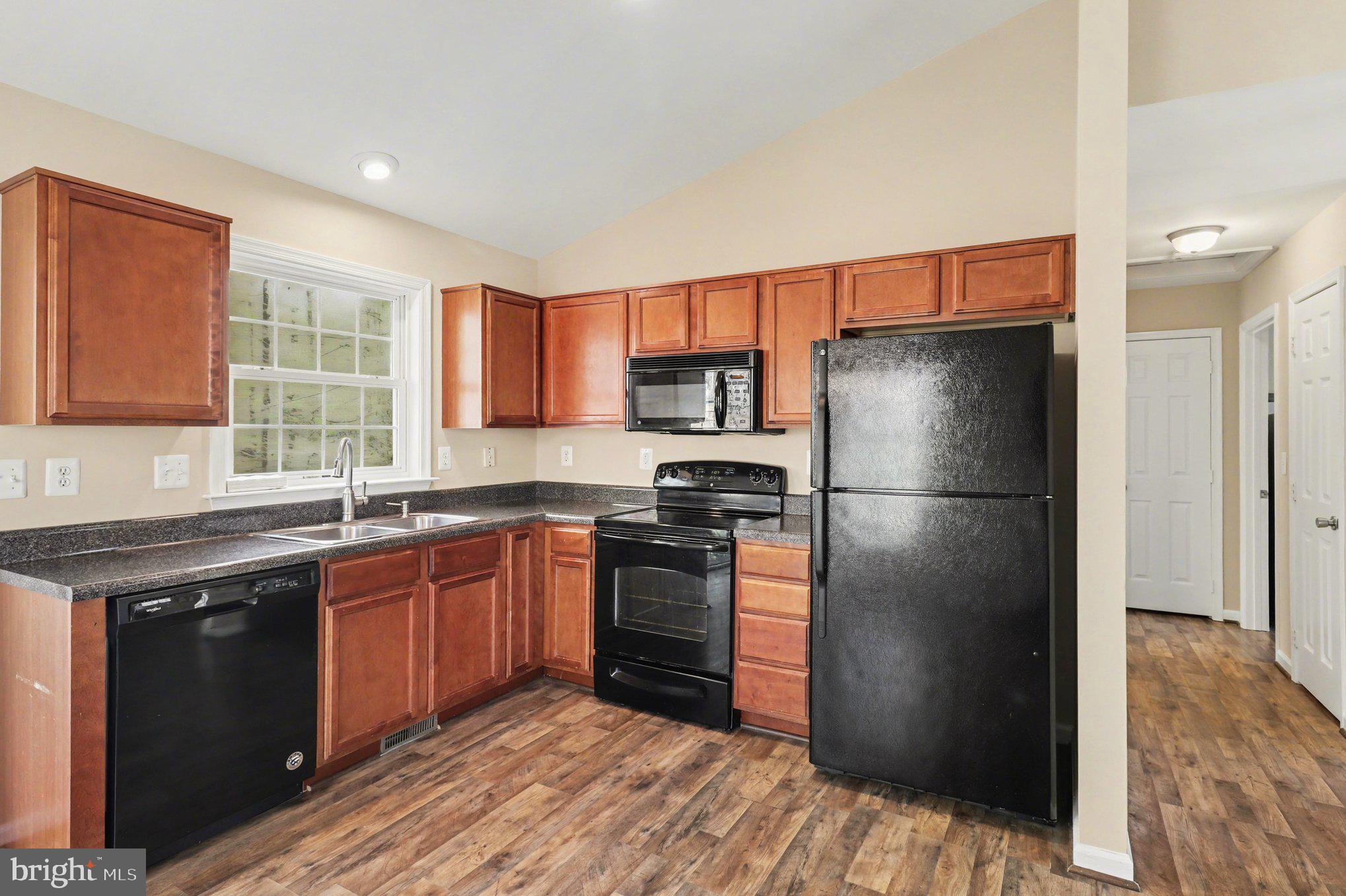876 Campers Lane Ruther Glen, VA 22546 - Photo 3 of 27 a kitchen with stainless steel appliances granite countertop a refrigerator stove and sink