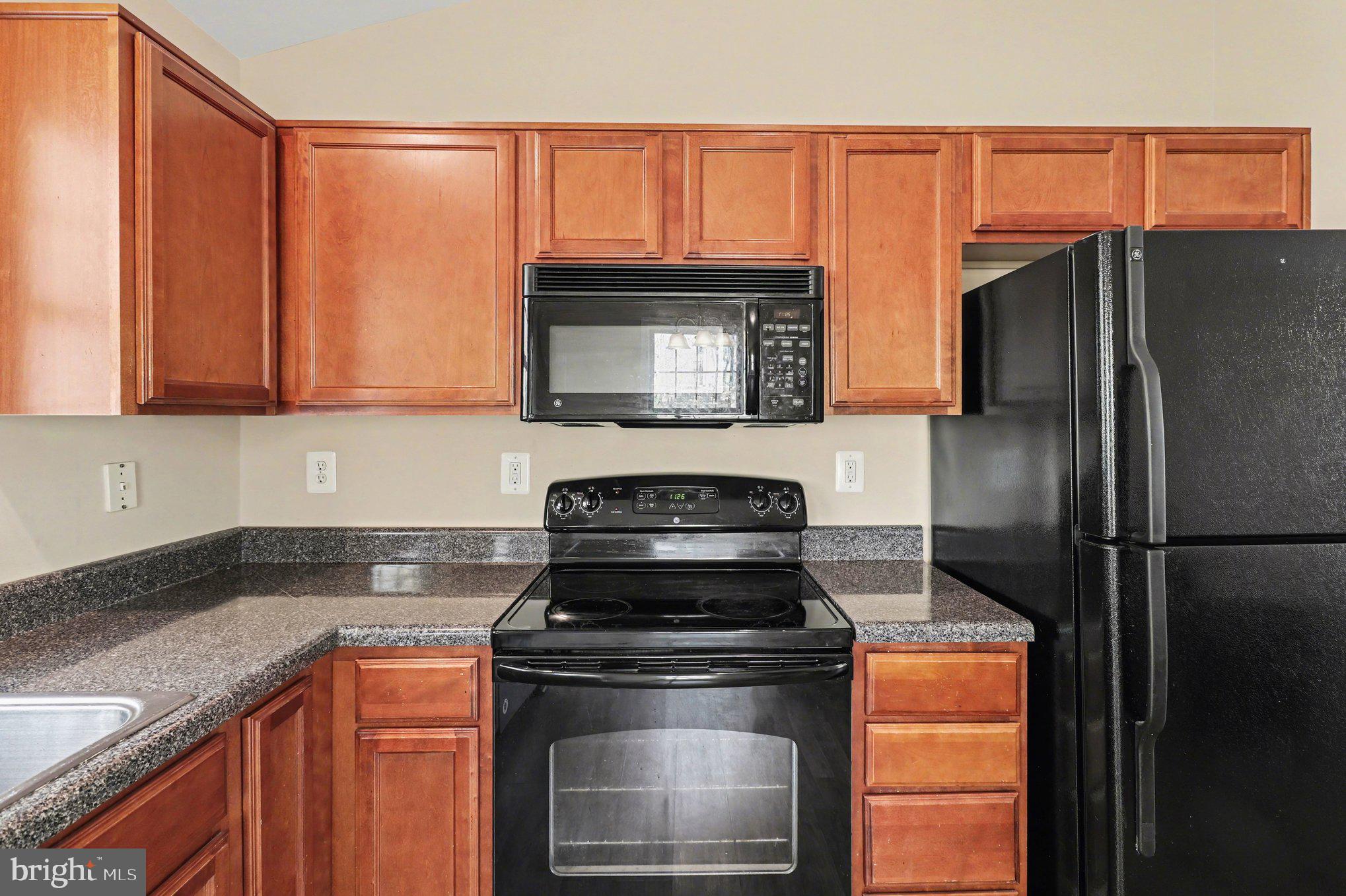 876 Campers Lane Ruther Glen, VA 22546 - Photo 4 of 27 a kitchen with granite countertop a refrigerator stove and microwave