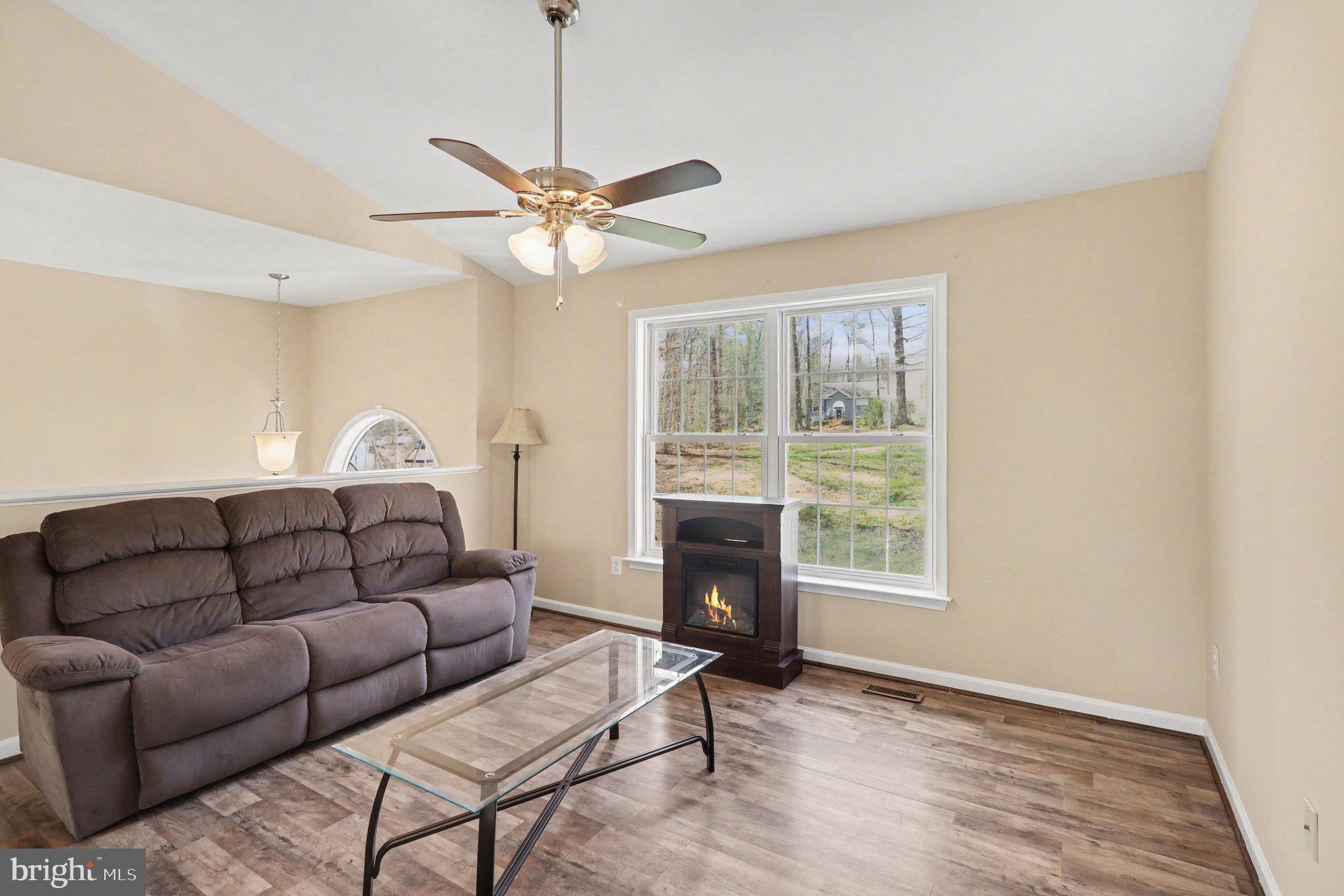 876 Campers Lane Ruther Glen, VA 22546 - Photo 8 of 27 a living room with furniture a window and a ceiling fan