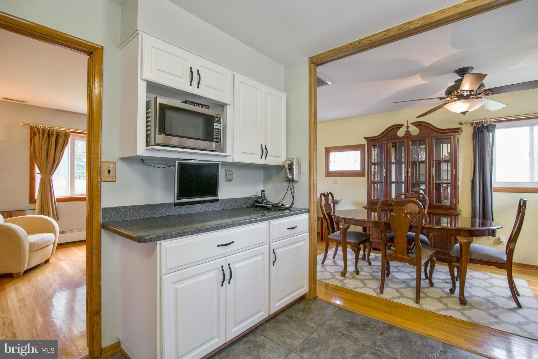 451 West Maple Road Linthicum Heights, MD 21090 - Photo 14 of 30 a kitchen with stainless steel appliances granite countertop a stove top oven a sink dishwasher and white cabinets with wooden floor