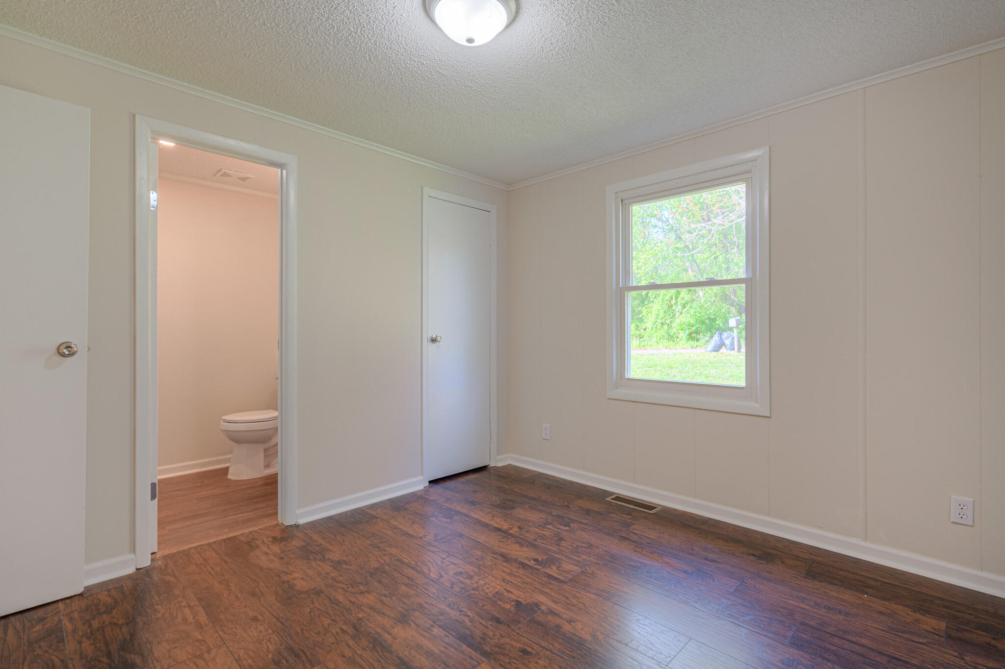 5216 Colonial Drive Dublin, VA 24084 - Photo 18 of 31 an empty room with a window and wooden floor