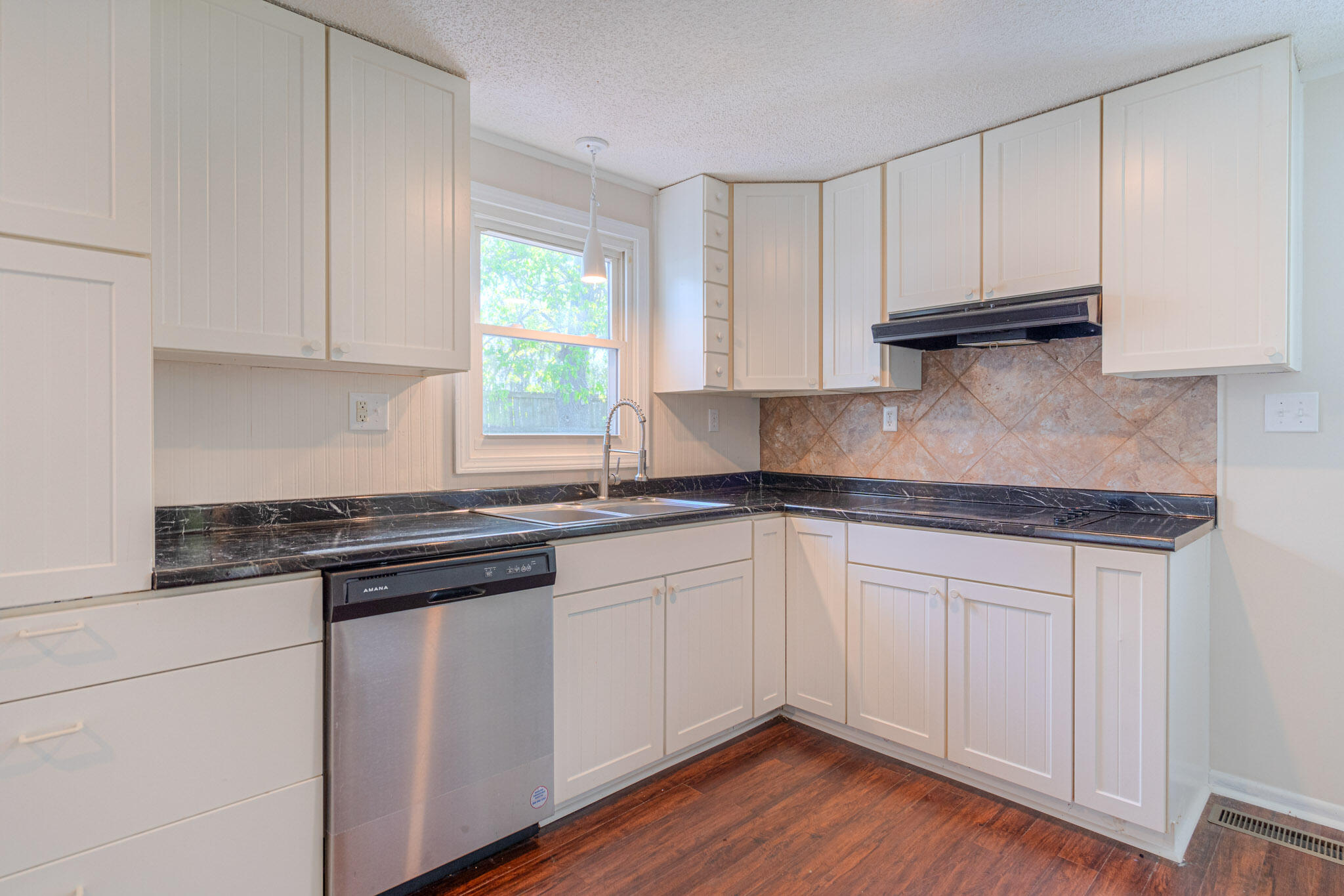 5216 Colonial Drive Dublin, VA 24084 - Photo 10 of 31 a kitchen with granite countertop white cabinets and a stove with wooden floor