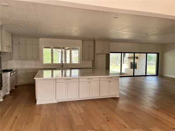 a large white kitchen with wooden floors