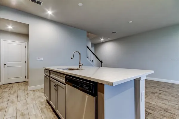 a kitchen that has a sink and a wooden floor