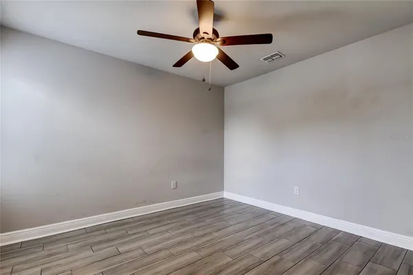 a view of an empty room with wooden floor