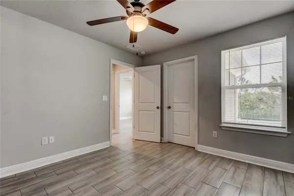 a view of an empty room with a window and wooden floor