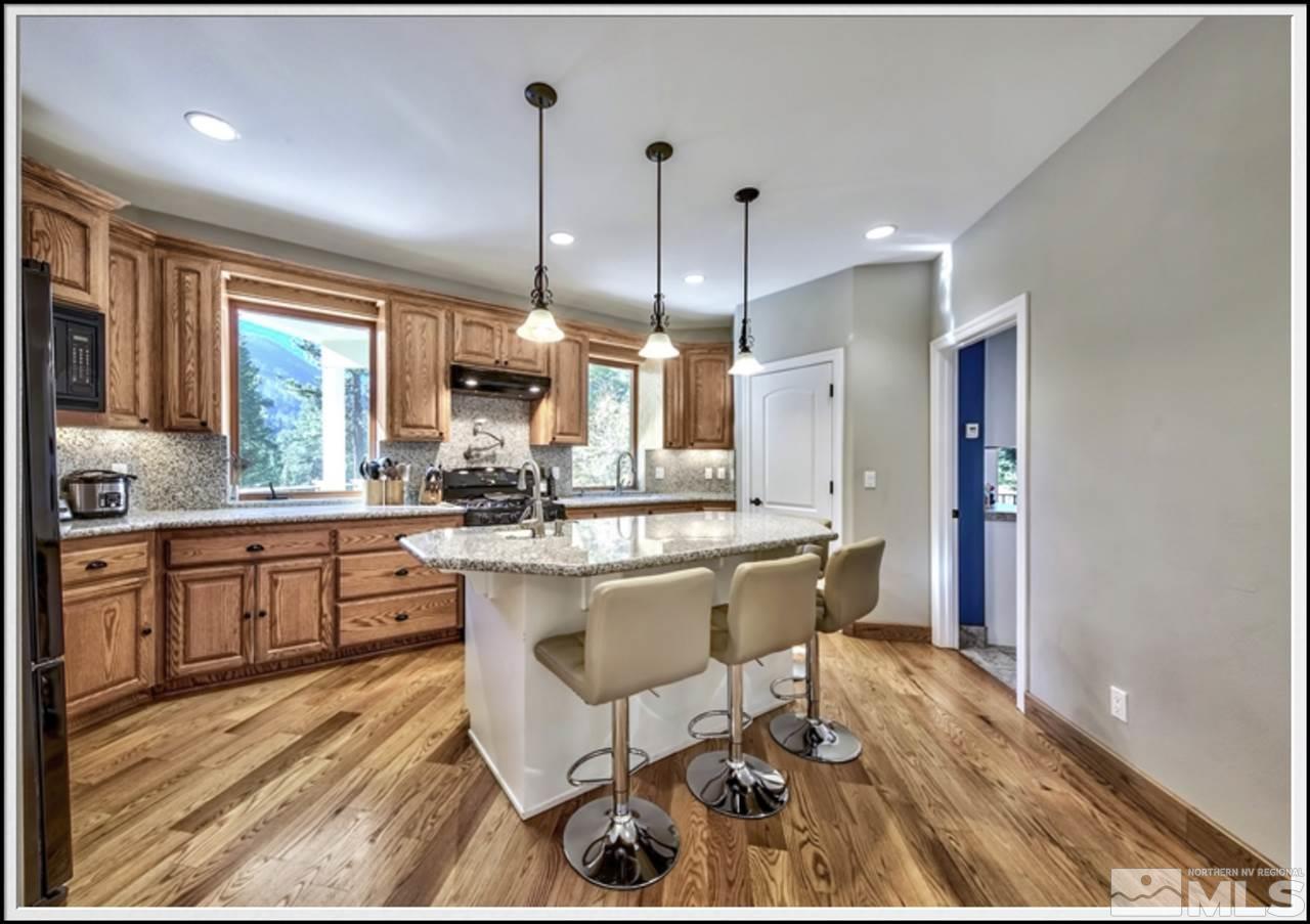 170 Granite Drive Stateline, NV 89449 - Photo 8 of 25 a kitchen with stainless steel appliances granite countertop a stove a sink dishwasher a refrigerator and white cabinets with wooden floor