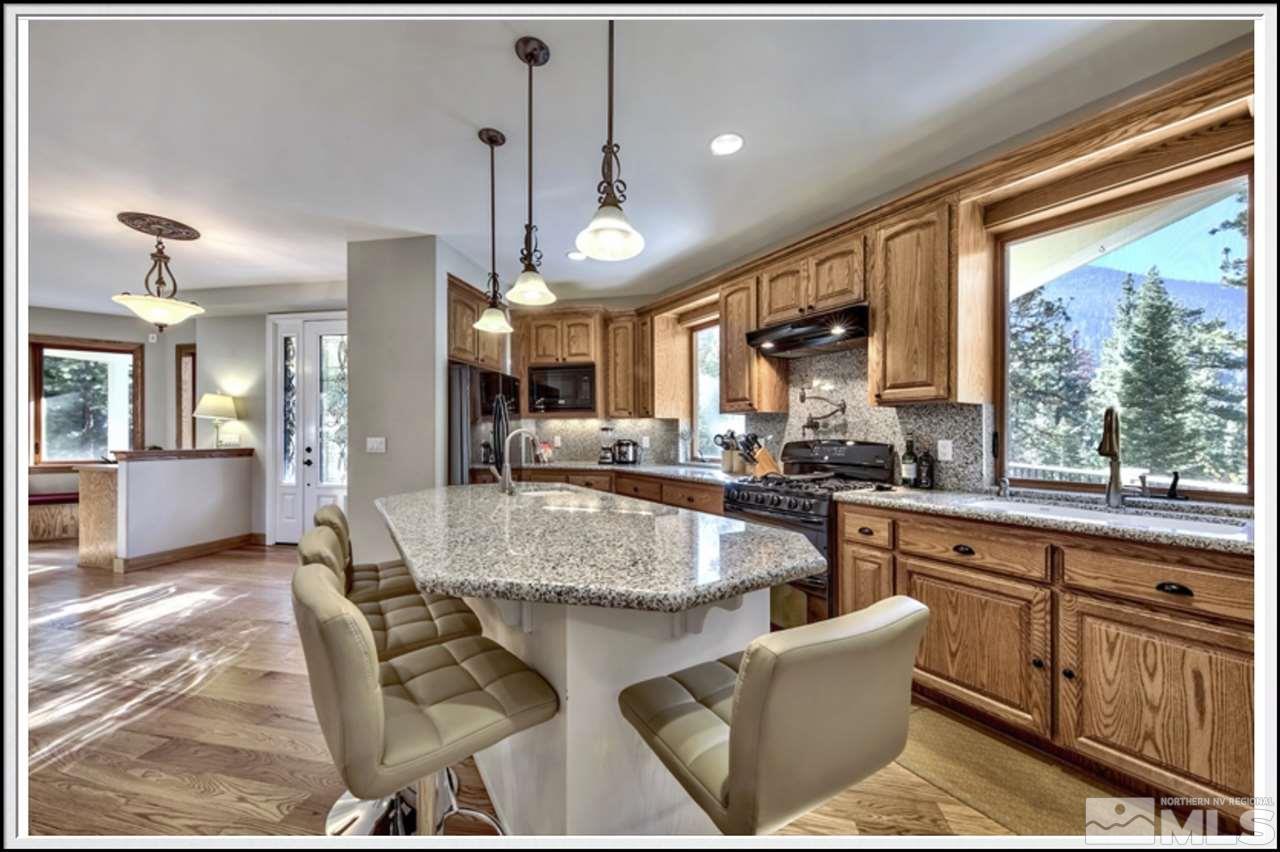 170 Granite Drive Stateline, NV 89449 - Photo 10 of 25 a large kitchen with stainless steel appliances granite countertop a stove a sink dishwasher a dining table and chairs with wooden floor