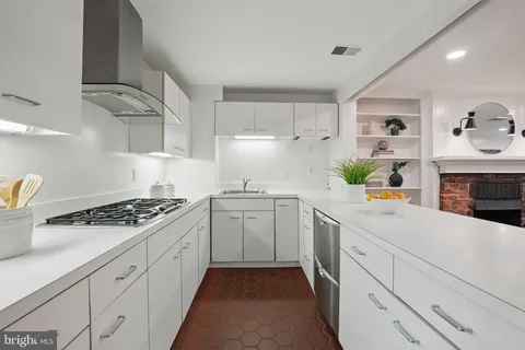 a kitchen with sink a stove and cabinets