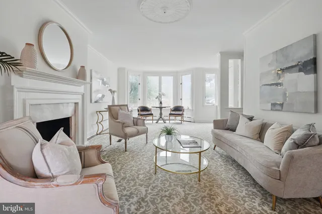 a living room with furniture a large window and a chandelier