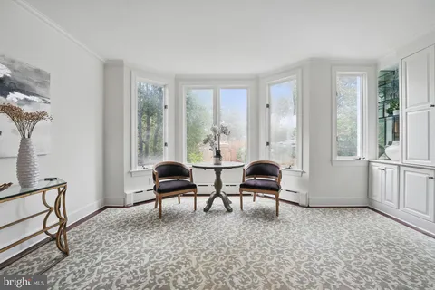a living room with furniture a large window and a chandelier