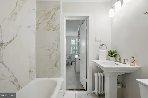 a living room with furniture a large window and a dining table