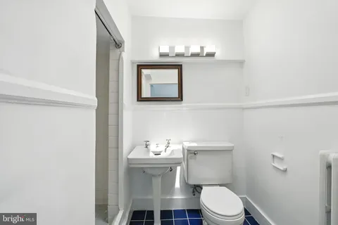a view of a backyard with table and chairs potted plants and large tree