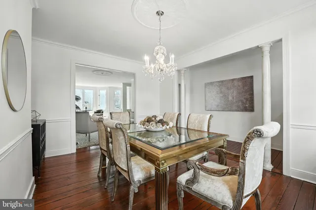 a view of a dining room with furniture a chandelier and wooden floor
