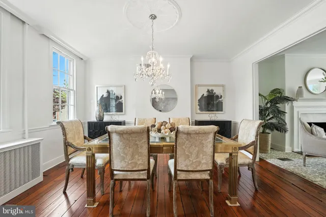 a view of a dining room with furniture a chandelier and wooden floor