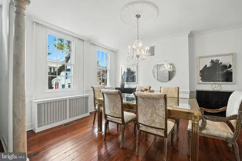 a view of a dining room with furniture a chandelier and wooden floor