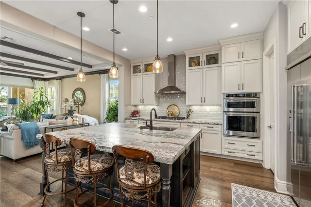 a kitchen with stainless steel appliances granite countertop a stove a refrigerator a oven a sink with a dining table and chairs