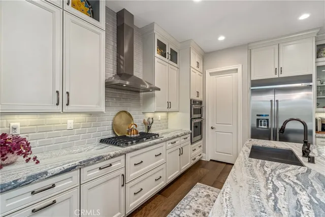 a kitchen with stainless steel appliances granite countertop a sink and a refrigerator