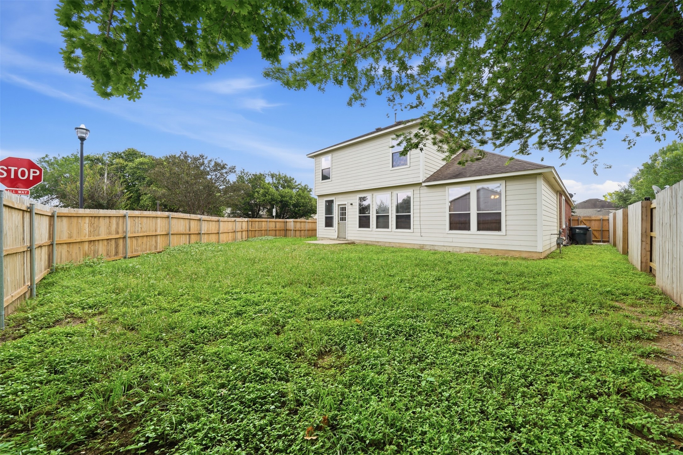 118 Invierno Street Kyle, TX 78640 - Photo 35 of 37 A spacious backyard enclosed by a tall wooden fence, offering ample private outdoor living.