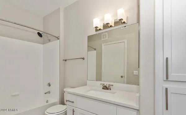 a bathroom with a sink vanity mirror and toilet