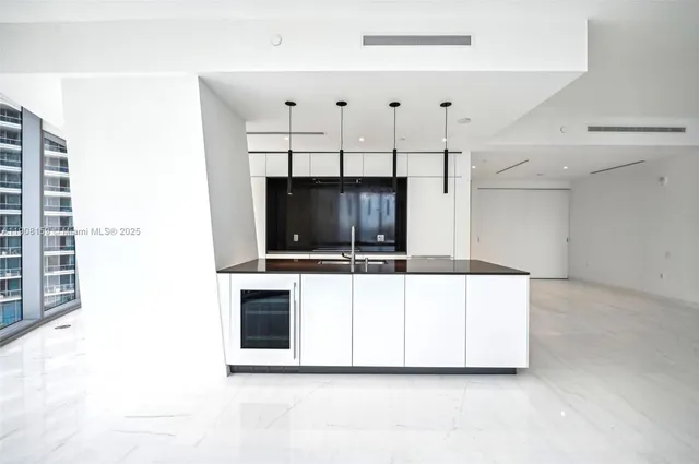 a kitchen with stainless steel appliances a stove a microwave and white cabinets