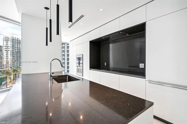 a kitchen with stainless steel appliances granite countertop a sink and a microwave