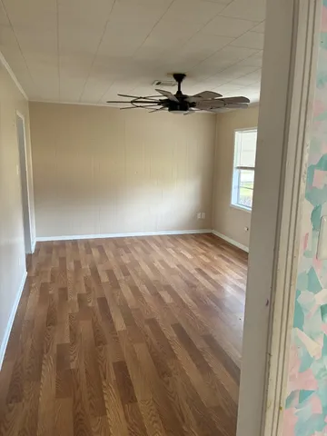 a view of a room with a window and wooden floor