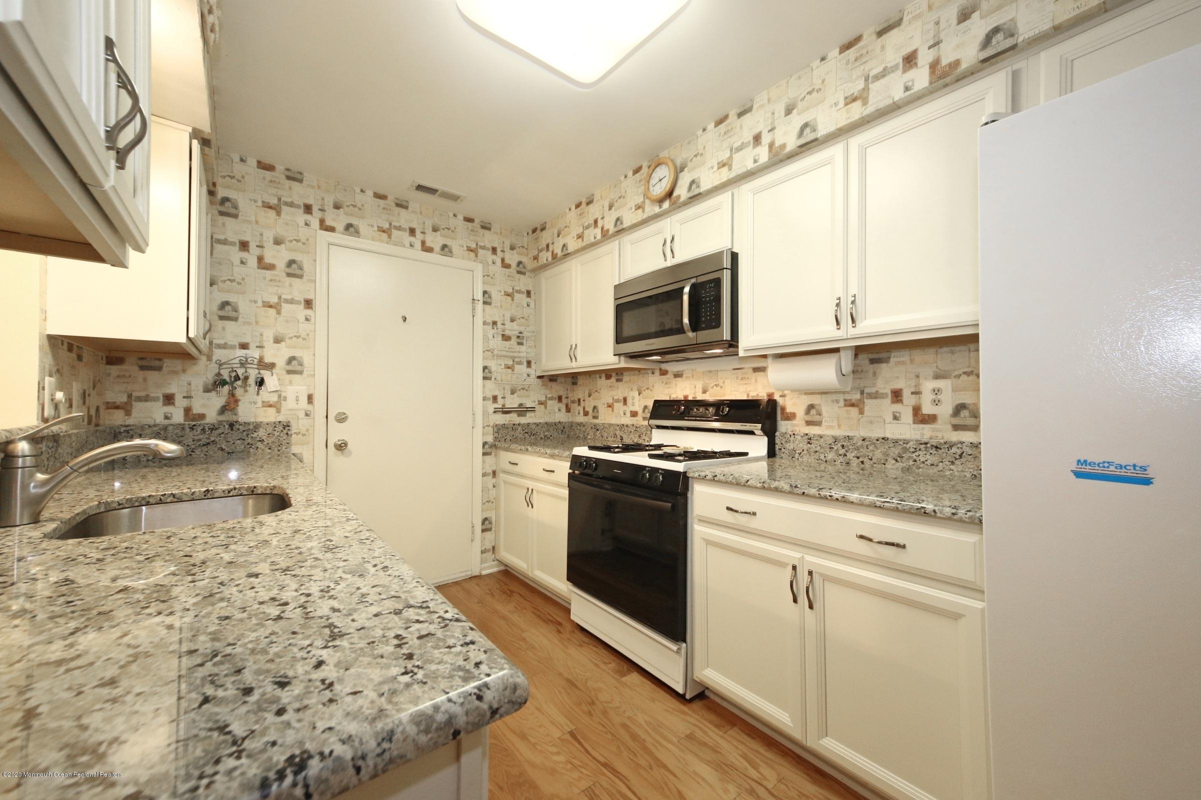 5 Racquet Road Wall, NJ 07719 - Photo 7 of 22 a kitchen with stainless steel appliances kitchen island granite countertop a stove refrigerator and microwave