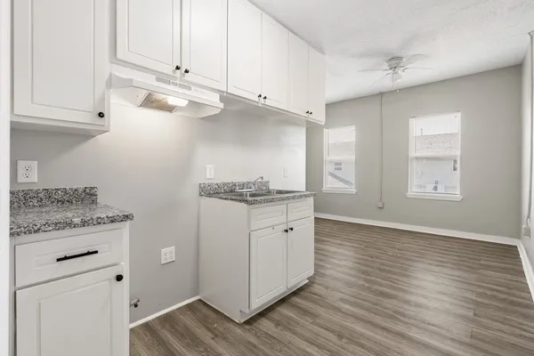 a kitchen with granite countertop white cabinets and white appliances