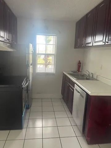 a kitchen with a sink a stove and cabinets