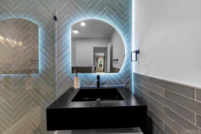 a bathroom with a tub shower sink and mirror