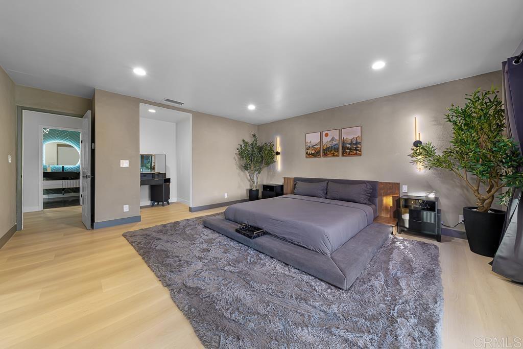 1286 Rippey Street El Cajon, CA 92020 - Photo 26 of 74 a spacious bedroom with a large bed and a potted plant
