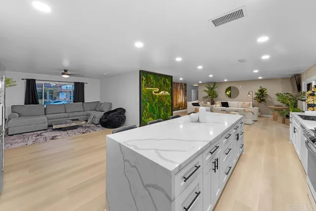 a kitchen with kitchen island a counter top space a sink stainless steel appliances and cabinets