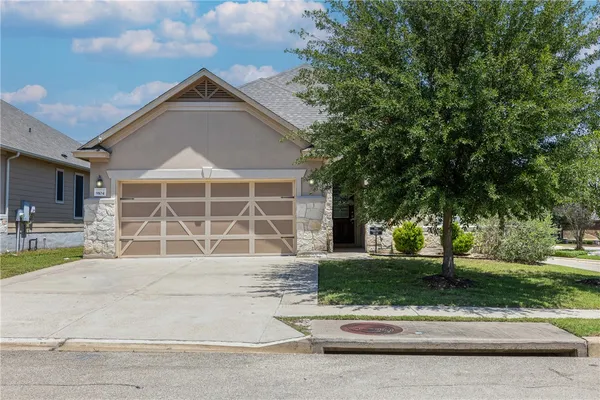 a front view of a house with a yard and a garage