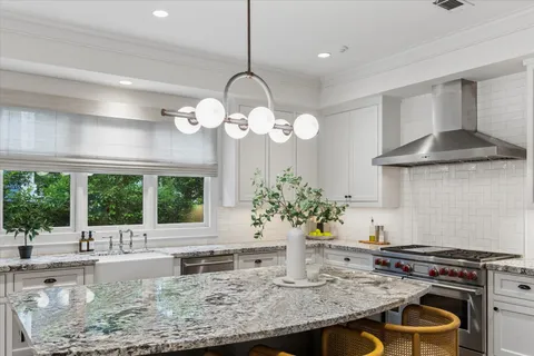 a kitchen with a table and a vase of flowers